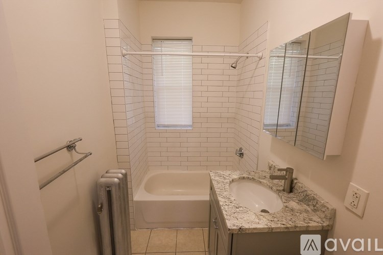 A bathroom with a tub, sink, and mirror.