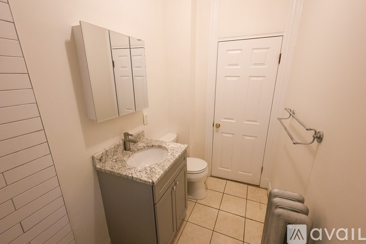 A bathroom with a sink, toilet, and a mirror.