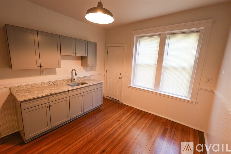 A kitchen with wooden floors and a marble countertop.