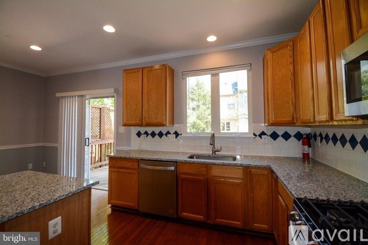 A kitchen with wooden cabinets and a granite countertop.
