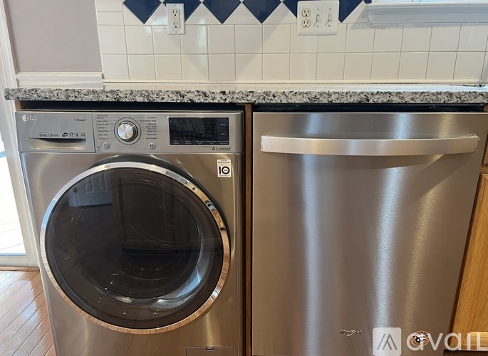 A stainless steel dishwasher and washing machine in a kitchen.
