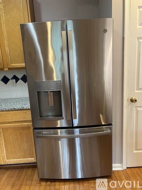 A stainless steel refrigerator with a water dispenser in the middle.