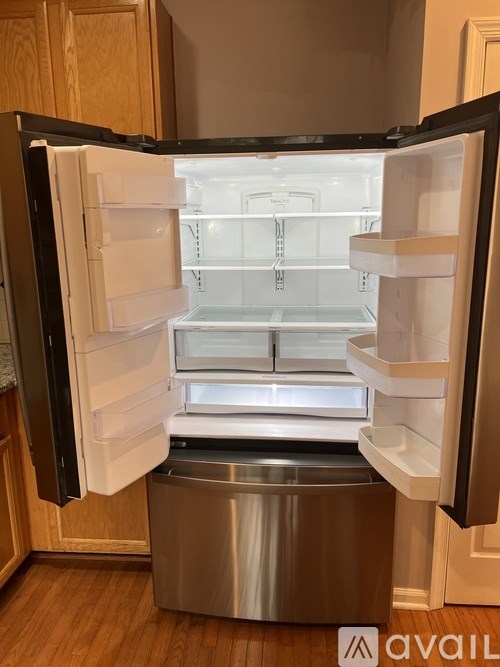 A stainless steel refrigerator with its door open in a kitchen.