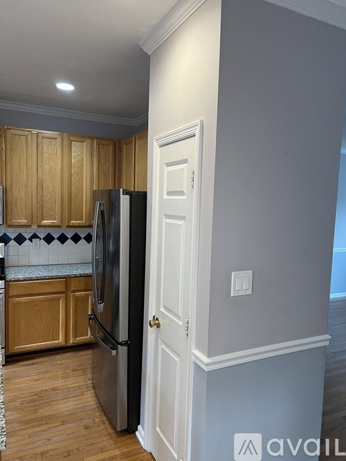 A kitchen with wooden cabinets and a black fridge.