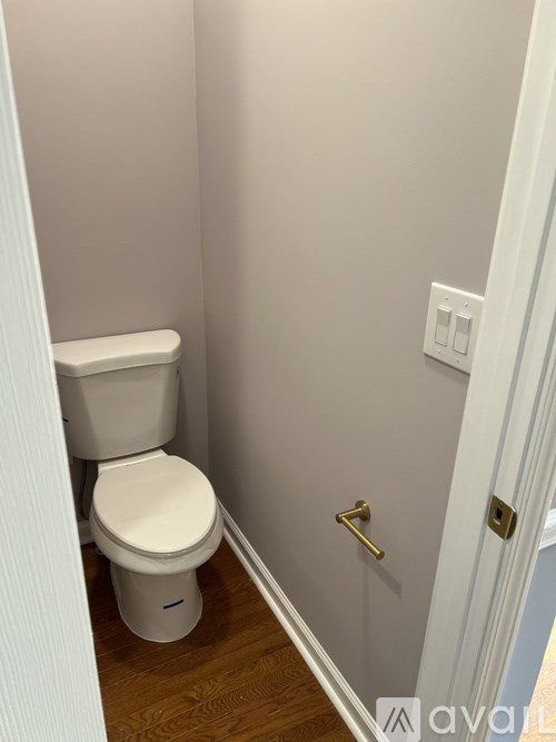 A white toilet in a small bathroom with a white door.