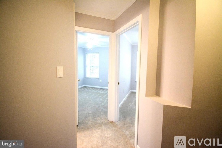 A room with a carpeted floor and a doorway leading to another room.