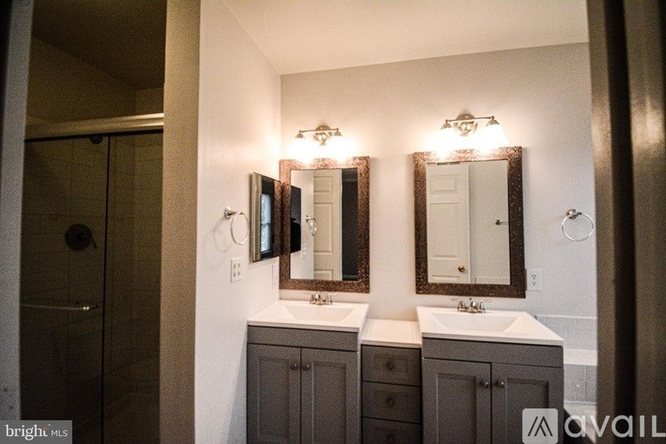 A bathroom with two sinks and two mirrors.