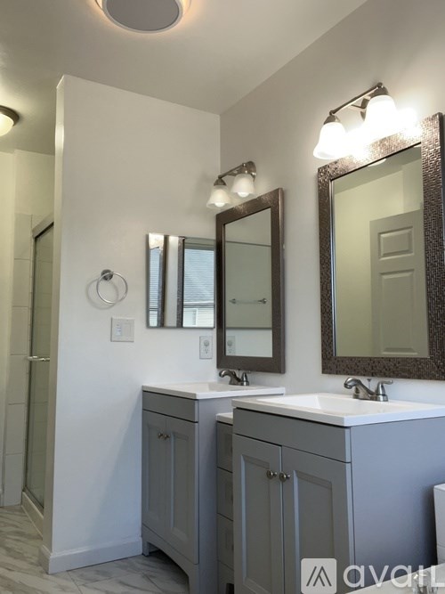 A bathroom with a sink, mirror, and lighting fixtures.