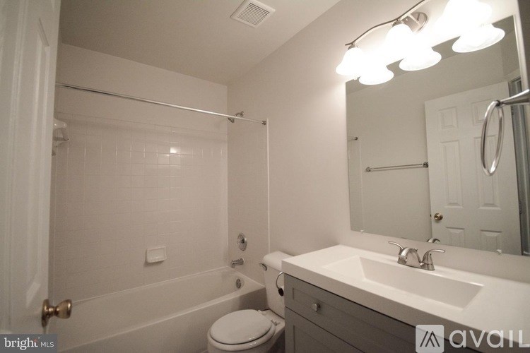 A bathroom with a toilet, sink, and mirror.