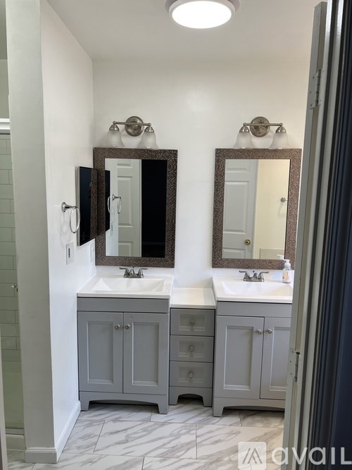 A bathroom with two sinks and two mirrors.