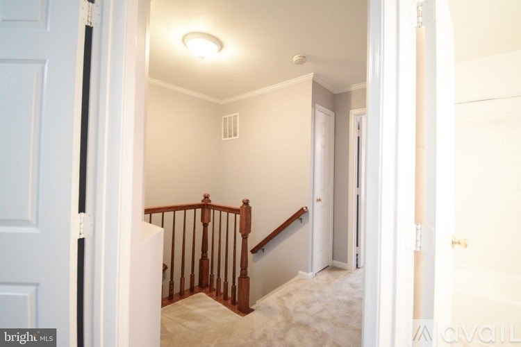 A hallway with a staircase and a white door.
