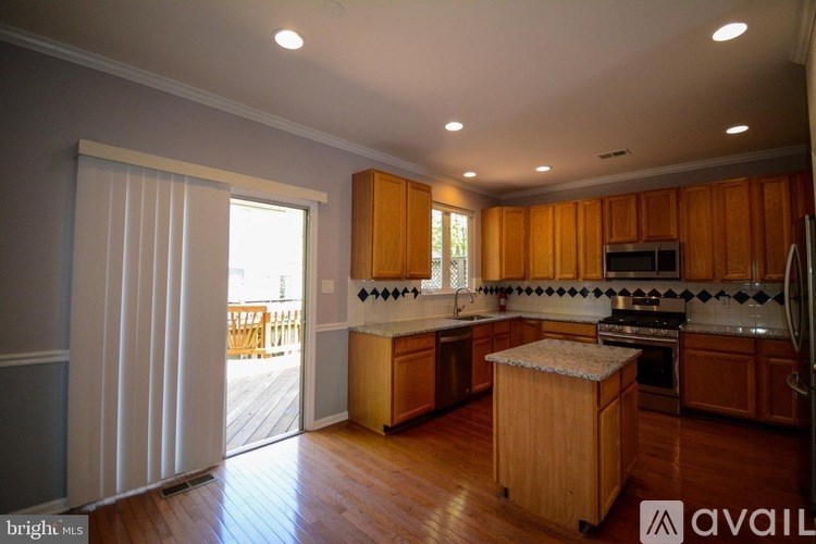 A kitchen with wooden cabinets and a granite countertop.
