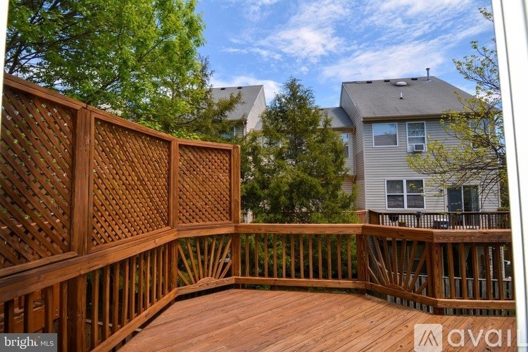 A wooden deck with lattice fencing and a house in the background.
