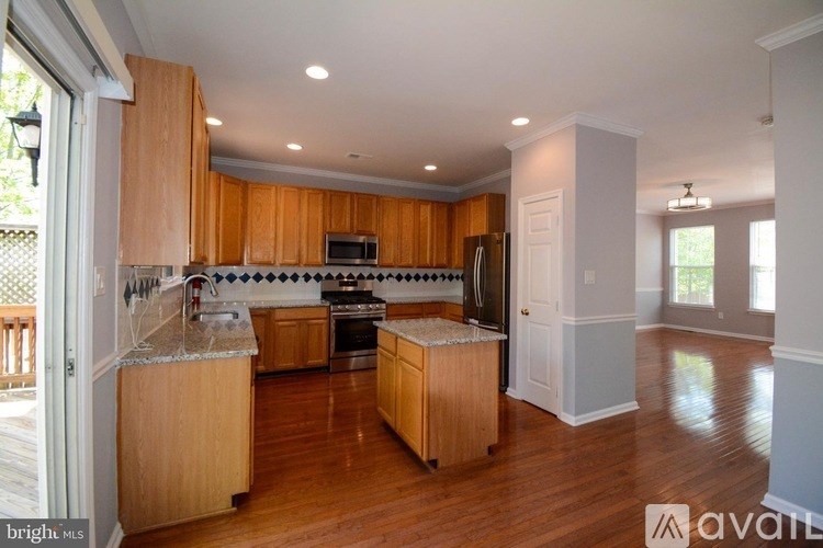 A kitchen with wooden cabinets and a black and white backsplash.