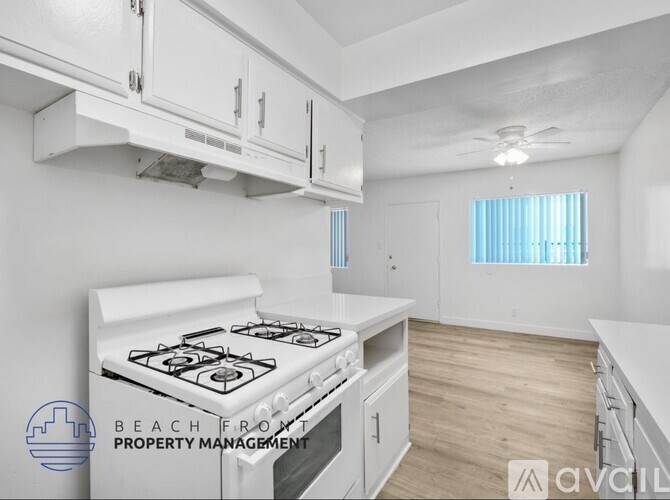 A kitchen with white cabinets and a stove top oven.