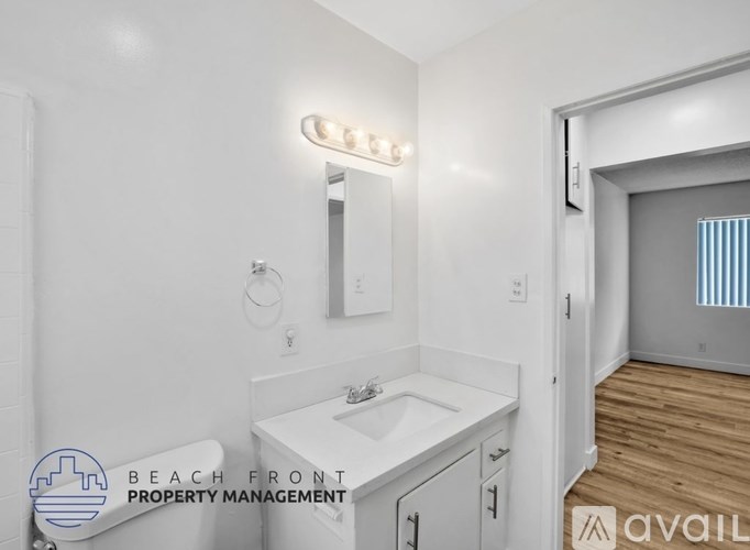 A bathroom with a sink, mirror, and light fixture.