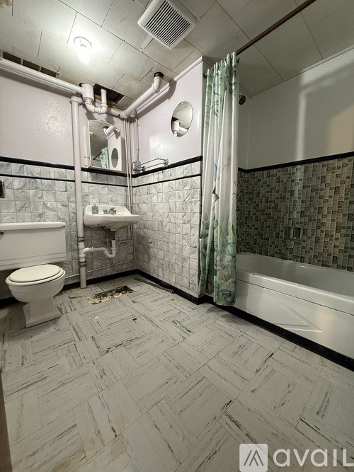 A bathroom with a toilet, sink, and shower.