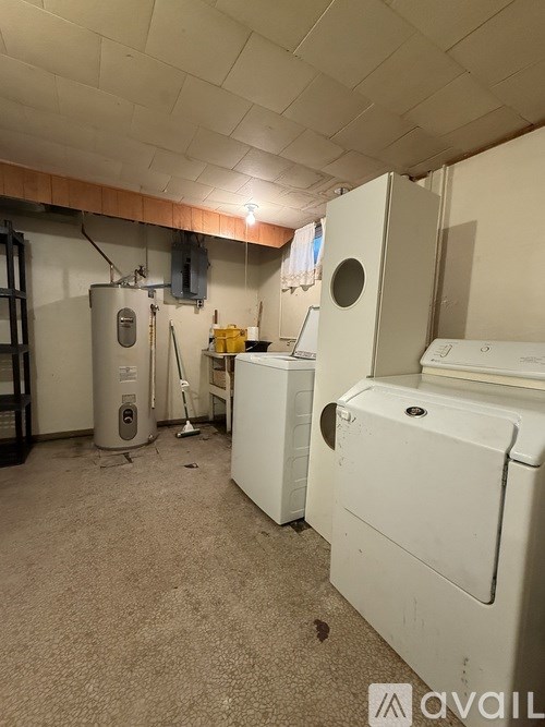 A room with a washing machine, dryer, and a water heater.