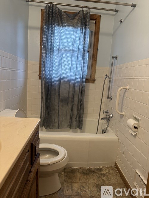 A bathroom with a toilet, tub, and shower.