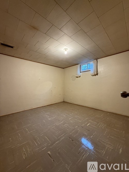 A room with a window and a tiled floor.