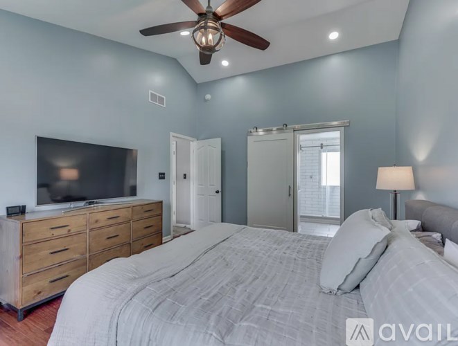 A bedroom with a bed, dresser, and television.