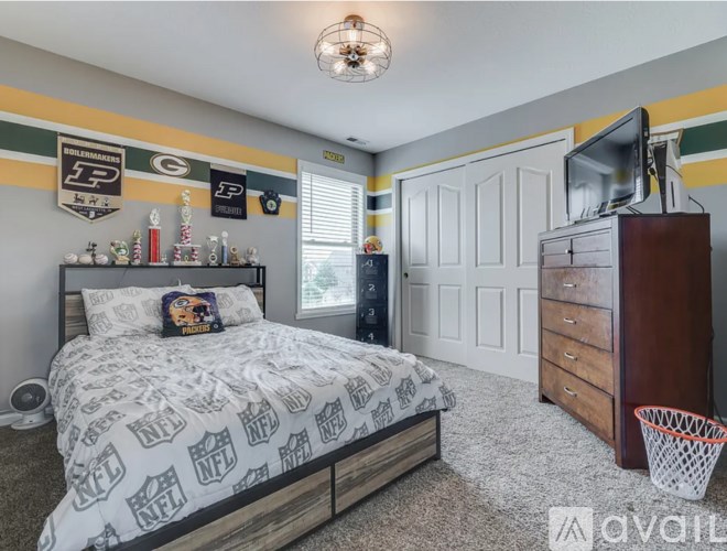 A bedroom with a bed, dresser, and a TV in the corner.