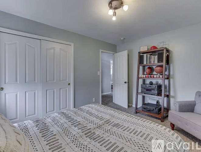 A bedroom with a bed, a couch, and a bookshelf.