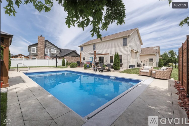 A swimming pool in a backyard with a house in the background.