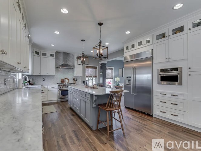 A modern kitchen with a marble countertop and stainless steel appliances.