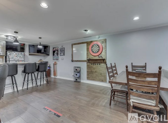 A dartboard is mounted on a wall in a room with wooden flooring and furniture.