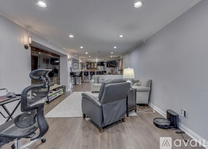 A spacious room with a grey chair and a black exercise bike.
