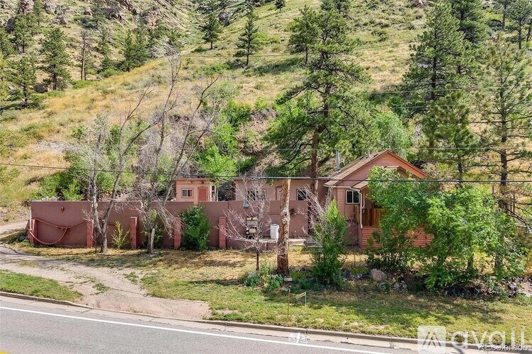 A house with a brown roof is surrounded by trees and grass.
