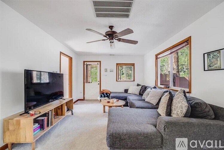 A living room with a grey couch and a television on a wooden stand.