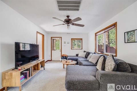A living room with a grey couch and a television on a wooden stand.