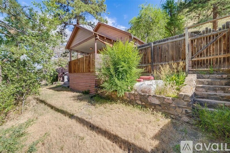A house with a wooden fence and a stone wall in front.
