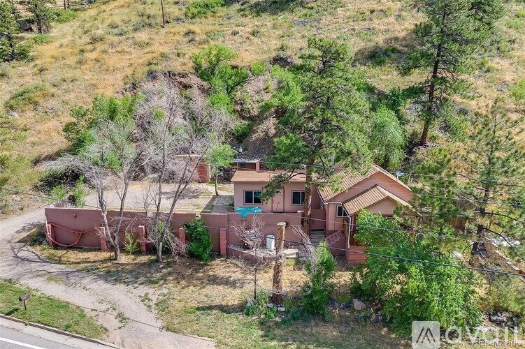 A house with a brown roof is surrounded by trees.