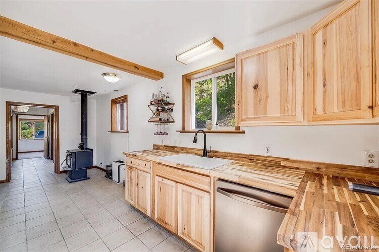 A kitchen with wooden cabinets and a stainless steel dishwasher.