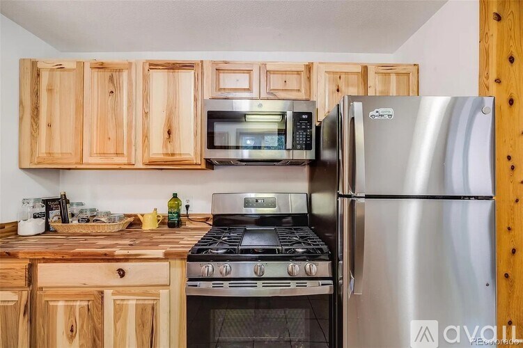 A kitchen with wooden cabinets and a stainless steel refrigerator.