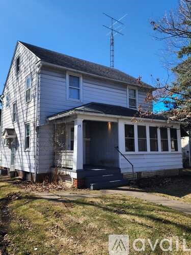 A white house with a grey roof and a black door.