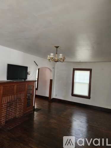 A room with a wooden floor and a chandelier.