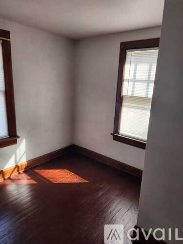 A room with a window and wooden floors.