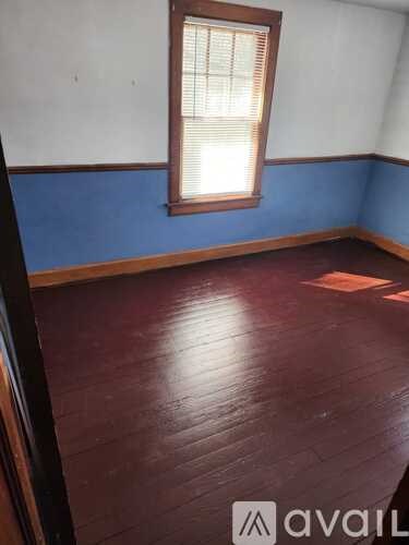 A room with a wooden floor and a window.