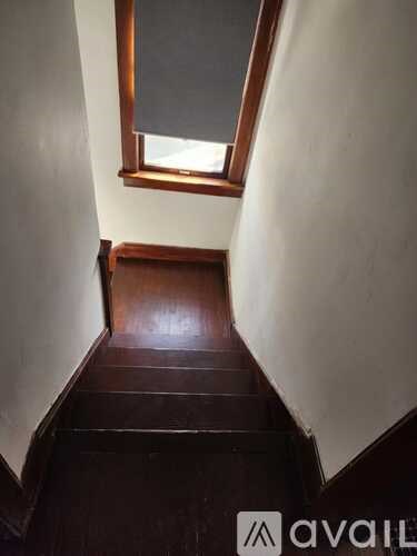 A wooden staircase with a skylight above it.