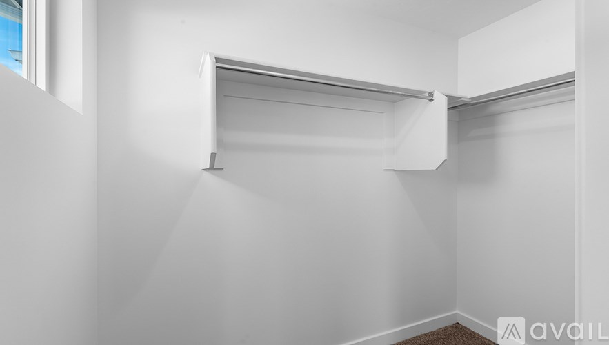 A white wall with a shelf and a window.