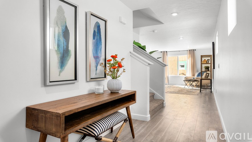 A room with a wooden desk and two framed artworks on the wall.