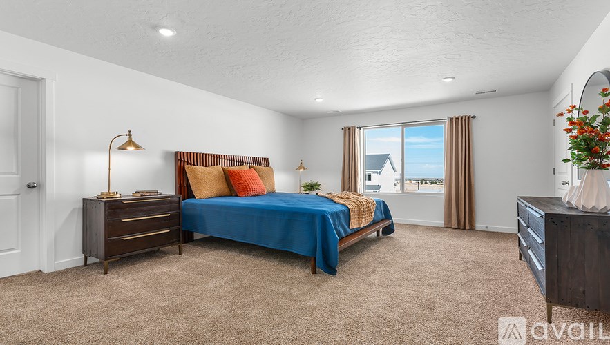 A bedroom with a bed, nightstand, and window.