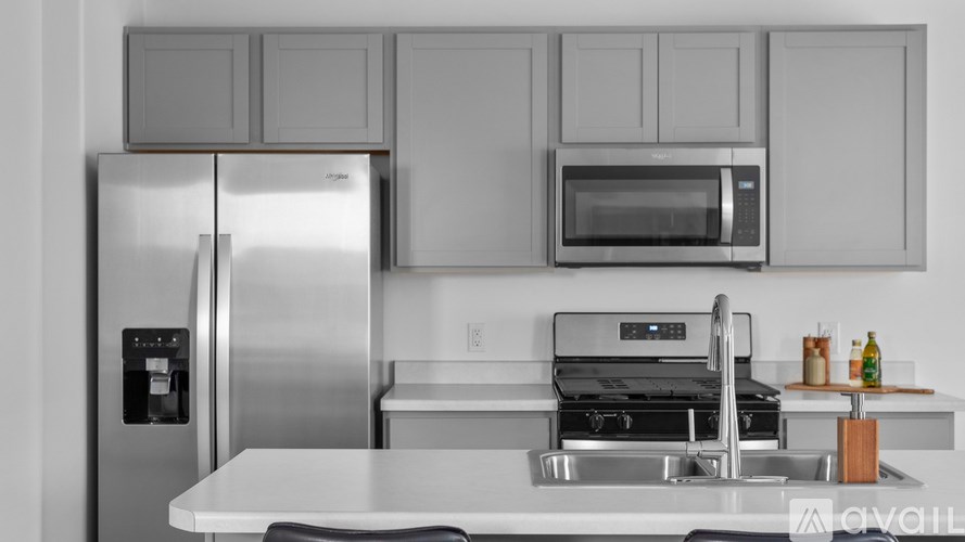 A modern kitchen with a stainless steel refrigerator, microwave, and oven.