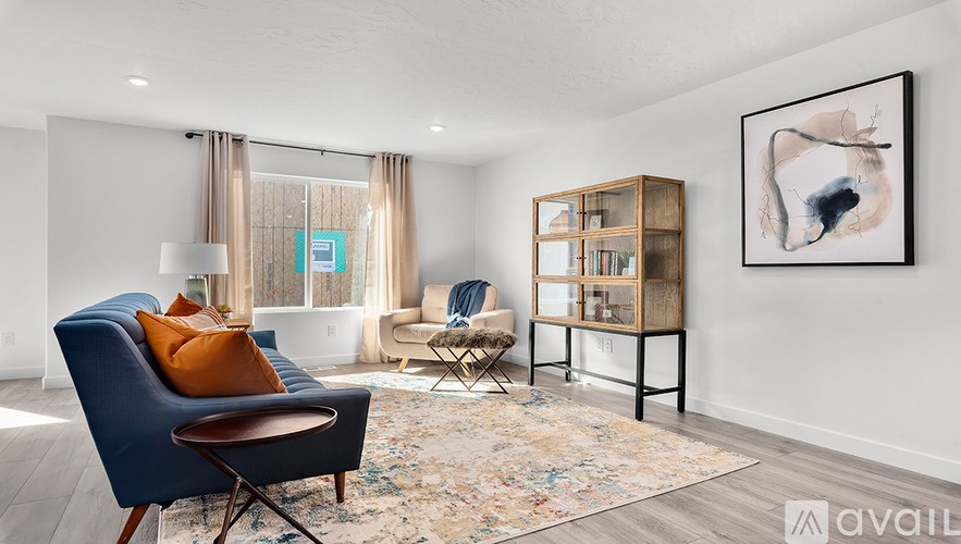 A living room with a blue chair and a rug.