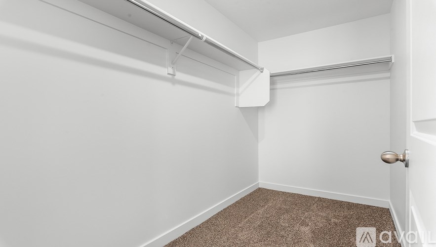 A small, empty room with a carpeted floor and white walls.