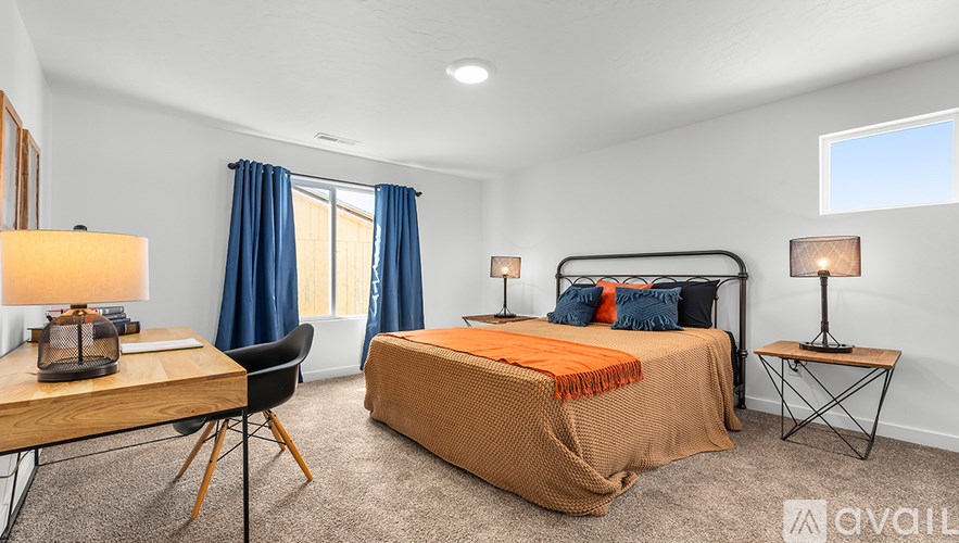 A bedroom with a bed, desk, and chair.